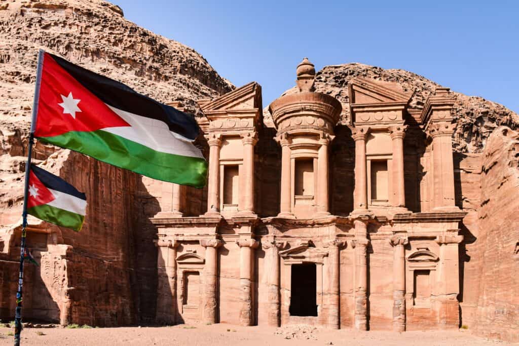 The stunning rock-carved monastery with flying Jordanian flags in Petra, Jordan.