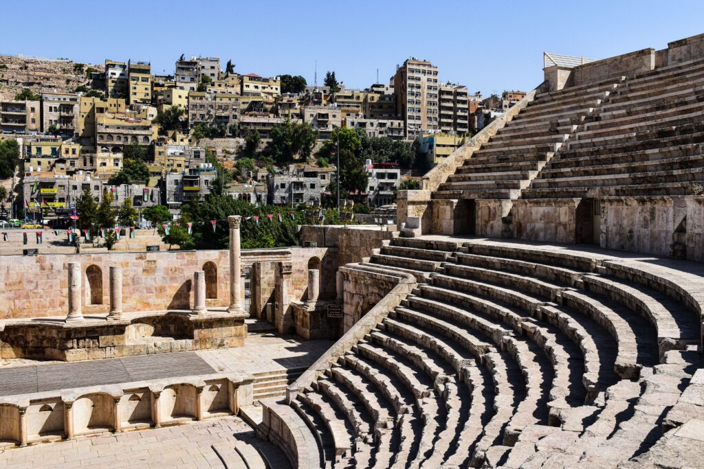 Explore the ancient Roman theater in Amman, showcasing historical architecture against a modern city backdrop.