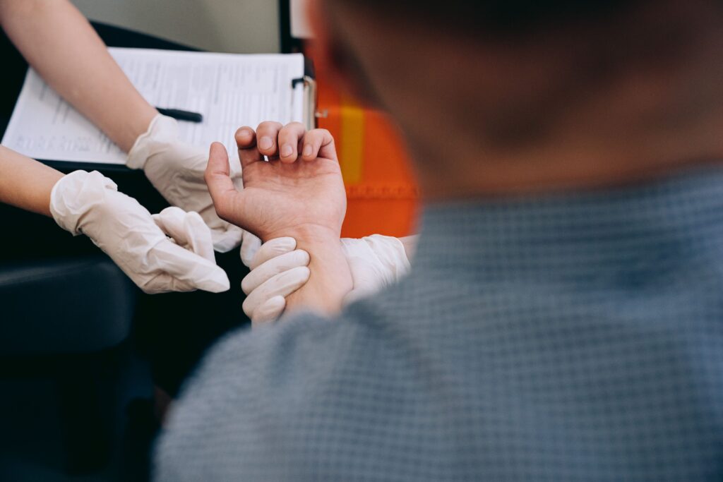 Healthcare professional checks man's pulse during medical examination.